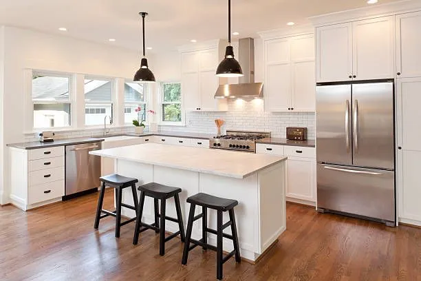 A bright remodeled kitchen with white cabinets and a center island
