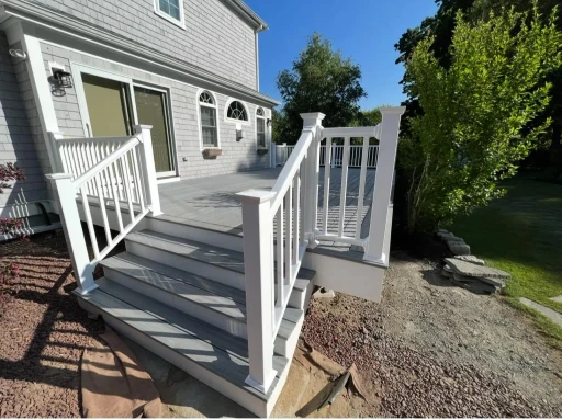 A finished low-maintenance composite deck with white railings on a South Shore home